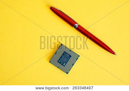 The Processor For Socket Lga 1151 On A Yellow Background Next To The Pen. Computer Techologies.