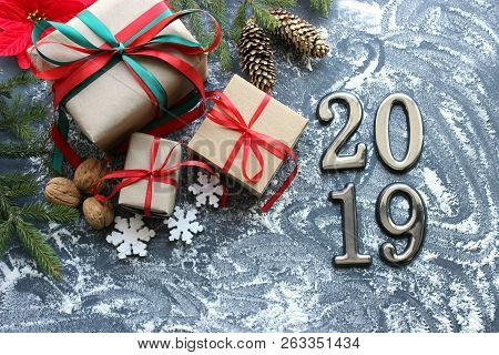 Festive Christmas Composition With Gifts, Boxes, Cones, Walnuts, Red Poinsettia Flowers On A Wooden 