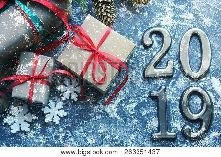 Festive Christmas Composition With Gifts, Boxes, Cones, Walnuts, Red Poinsettia Flowers On A Wooden 