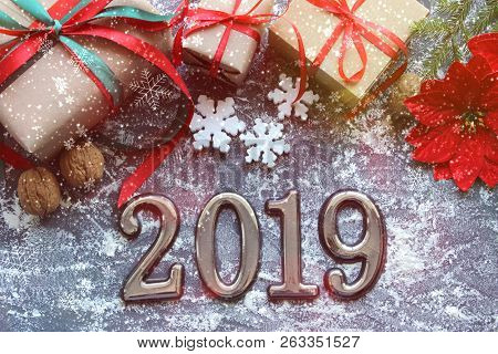 Festive Christmas Composition With Gifts, Boxes, Cones, Walnuts, Red Poinsettia Flowers On A Wooden 