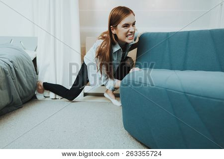 Young Woman Moves The Sofa In The New Apartment. Reshuffle In The Room Concept. Domestic Problems. C