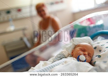 Beautiful newborn baby boy laying in crib in prenatal hospital