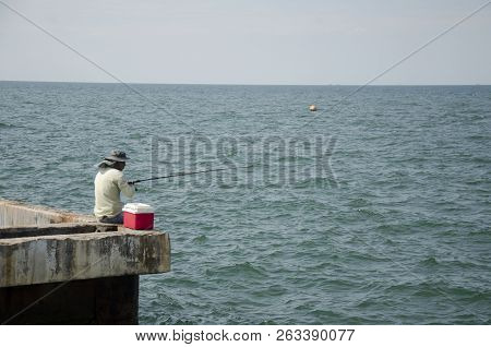 Thai Angler Or Fisherman Use Fishing-rod Fishing Fish In The Sea At Coast Of Laem Thaen Cape And Sce