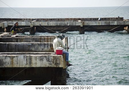 Thai Angler Or Fisherman Use Fishing-rod Fishing Fish In The Sea In Chonburi, Thailand