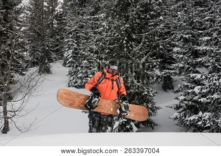 Man Walking With The Snowboard In Hands In The Mountain Up The Hill In The Popular Tourist Resort In
