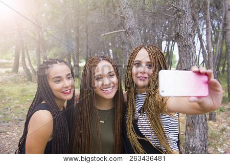 Three Young And Beautiful Girls, With Braided Hair, Taking Selfie