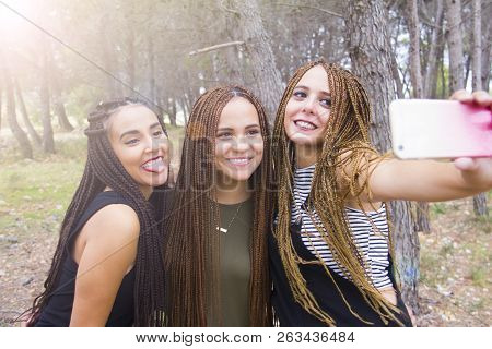 Three Young And Beautiful Girls, With Braided Hair, Taking Selfie