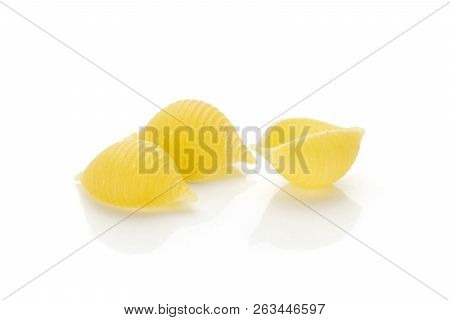 Group Of Three Whole Raw Yellow Pasta Conchiglie Variety Like Shells Isolated On White Background