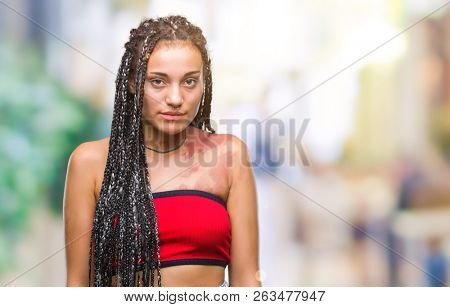 Young braided hair african american with pigmentation blemish birth mark over isolated background with serious expression on face. Simple and natural looking at the camera.