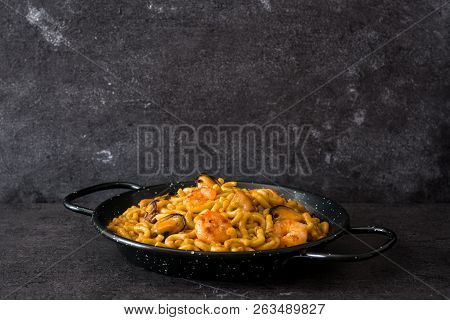 Traditional Spanish Fideua. Noodle Paella On Black Stone. Copyspace