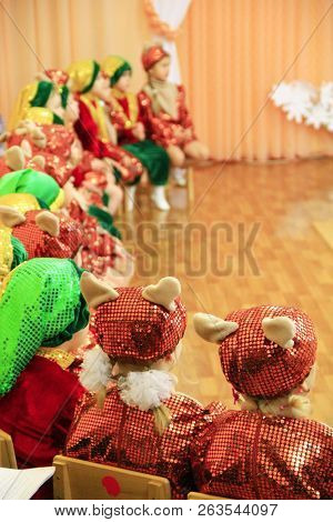 Team Of Children On Matinee At Kindergarten. Children In Smart Suits Sit On Chairs During Performanc