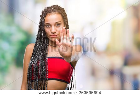 Young braided hair african american with pigmentation blemish birth mark over isolated background doing stop sing with palm of the hand. Warning expression with negative and serious gesture 