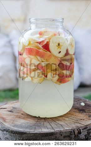 Apple Vinegar Making - Apple Pieces Floating In A Glass In Rustic Interior