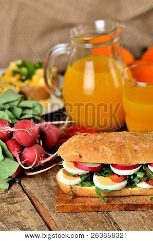 Baguette Sandwich With Egg, Arugula Salad, Tomatoes And Radish