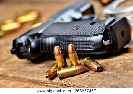 Close-up Of 9mm Handgun, Bullets And Handcuffs