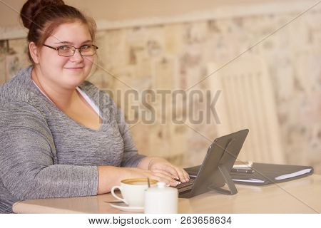 Beautiful Young Adult Woman Smiling At The Camera With Her Hands Sill On The Keyboard After Being In