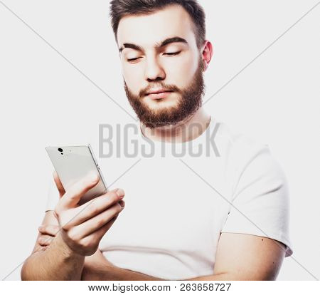 Tehnology and people concept: Bearded man  typing sms on white  background