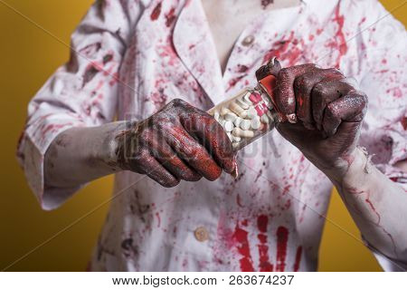 Scary Damaged Girl In Nurce Halloween Costume Looking Like Zombie With Pills On Yellow Background