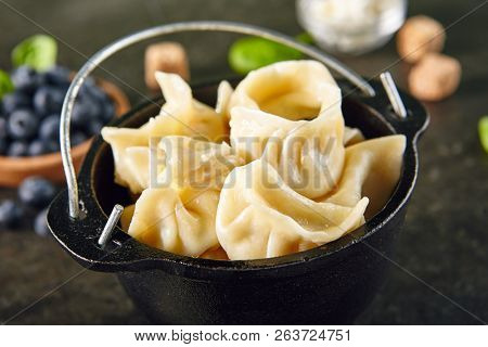 Dumplings with Blueberries. Berriesjiaozi, Dimsum, Momo or Ha Gao on Dark Background. Asian Food of Dough Based on Flour Stuffed with Meat, Fish, Vegetables, or Sweets