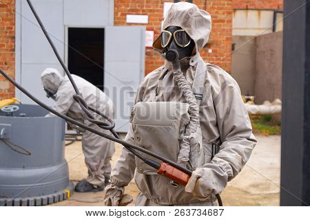 Man Works In A White Chemical Protection Suit And A Gas Mask. Chemical Hazards.