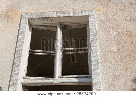 A Broken Window In An Old Abandoned Building. Broken Glass On The Window Site. Old Building.