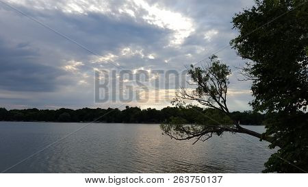 Sunlight Peeking Out Of Overcast Sky Over Lake In North America/canada.
