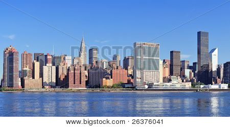 Manhattan midtown skyline panorama over East River with urban skyscrapers and blue sky in New York City