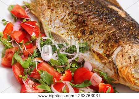 Fish Dish. Fried Crucian Carp With Green Salad On White Plate Close-up. Fried Freshwater Fish With C