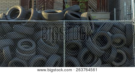 Old Tires Inside A Mesh Fence With Barbed Wire