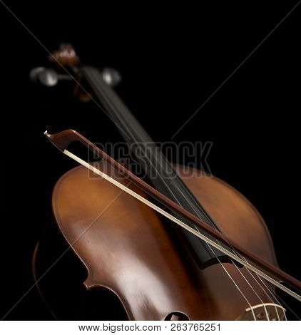 Close Up Of A Cello And A Bow Set Against A Black Background