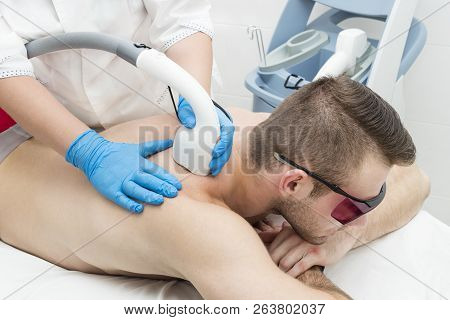 Man On The Procedure Of Laser Hair Removal In The Beauty Salon