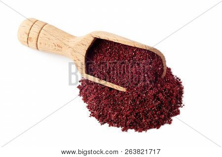 Ground Sumac Spice Powder In Wooden Scoop Isolated On White Background