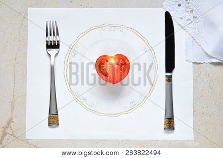 Half A Tomato In The Form Of A Heart On A Painted Plate. Concept Of Vegetarian Food. Restrictions On