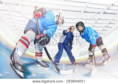 Young Hockey Players And Coach Dropping Puck