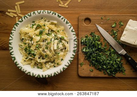 Turkish Noodle / Eriste With Cheese And Parsley On A Wooden Surface.