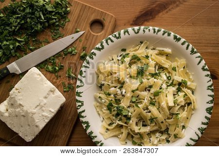Turkish Noodle / Eriste With Cheese And Parsley On A Wooden Surface.