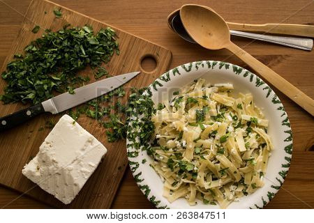 Turkish Noodle / Eriste With Cheese And Parsley On A Wooden Surface.