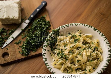 Turkish Noodle / Eriste With Cheese And Parsley On A Wooden Surface.