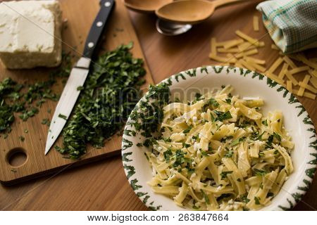 Turkish Noodle / Eriste With Cheese And Parsley On A Wooden Surface.