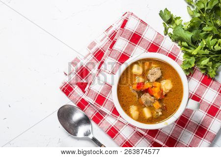 Traditional Hungarian Goulash Soup On White Stone Table. European Cuisine. Top View With Copy Space.