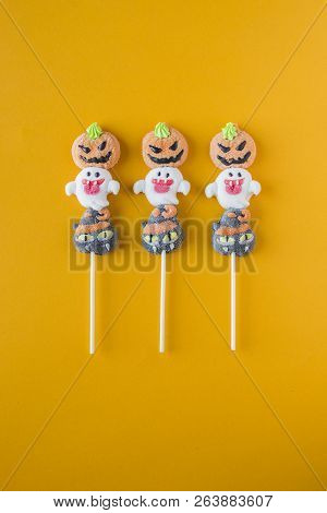 Halloween Candies Arranged In An Alternating Pattern On An Colored Background