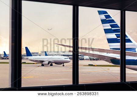 View of airplane fuselage tail through window at airport
