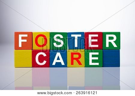 Close-up Of Foster Care Cubic Blocks On Reflective Background
