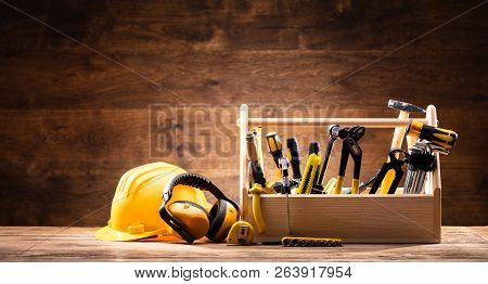 Safety Equipment Near Toolbox With Various Worktools On Wooden Surface