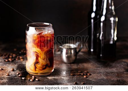 Cold Brew Iced Coffee In A Glass With Swirls Of Milk Or Creamer