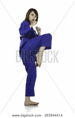 Female Red Belt Student Practicing Tae Kwon Do Martial Arts Moves In A Blue Dobok Or Gi (uniform) Is