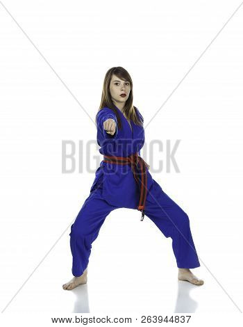 Female Red Belt Student Practicing Tae Kwon Do Martial Arts Moves In A Blue Dobok Or Gi (uniform) Is