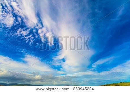  Journey to the ends of the earth. Cirrostratus cllouds of fanciful shapes in the blue sky of Australia. The concept of photo and ecological tourism
