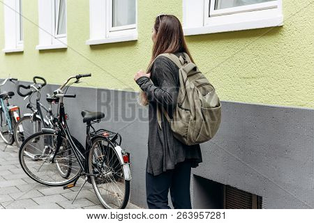 Tourist With A Backpack Is Looking For Booked Online Accommodation In An Unfamiliar City. Or A Stude