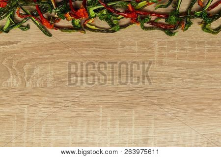 Dry Red And Green Bell Pepper On Wood Background. Space For Text